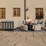 Modern outdoor corner sofa set with grey cushions and two round stools on patio