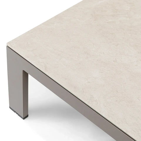 Closeup of beige stone effect coffee table with grey metal legs