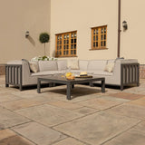 Grey outdoor corner sofa set with cushions and matching coffee table on a stone patio