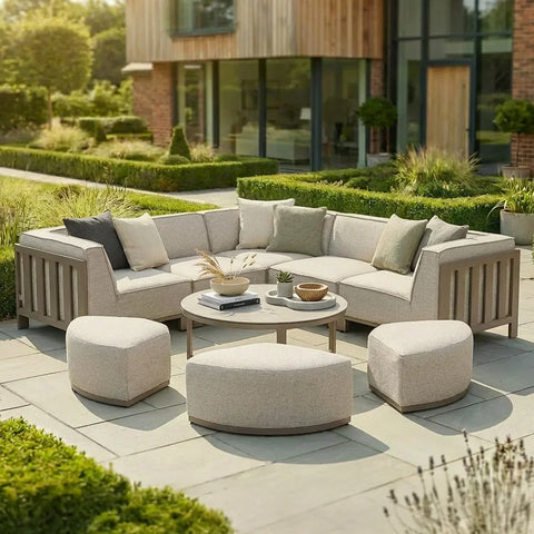 Beige outdoor corner sofa set with matching stools and round coffee table on patio