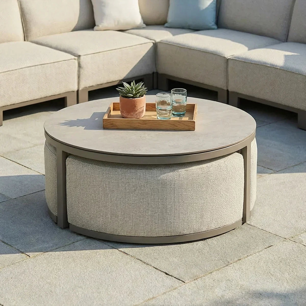 Round outdoor coffee table with light fabric panels and tray on tiled patio