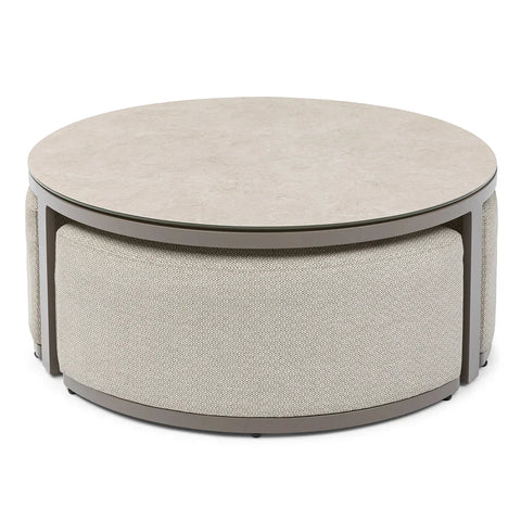 Round coffee table with beige stone top and fabric upholstered base, modern design