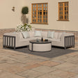 Grey outdoor corner sofa set with round coffee table on patio, patterned cushions included