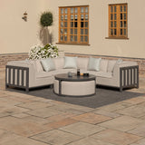 Grey outdoor corner sofa set with round coffee table on patio, patterned cushions included