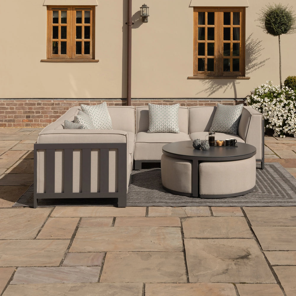 Beige outdoor corner sofa set with cushions and round coffee table on patio