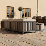 Grey outdoor sofa set with beige cushions on stone patio, matching ottoman and table