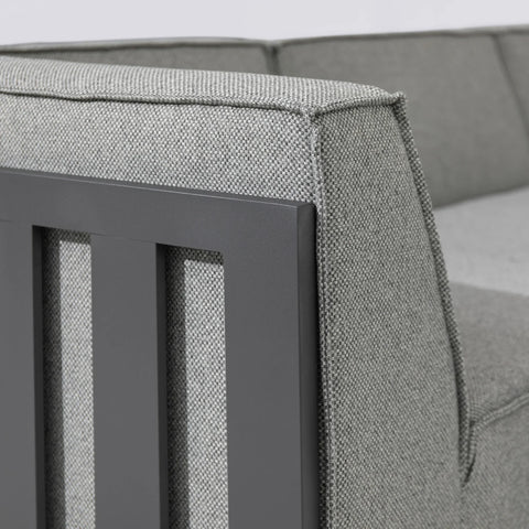Grey fabric sofa with metal armrest panel, close-up of upholstery and frame detail