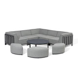 Grey outdoor corner sofa set with three matching stools and a round coffee table