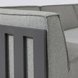 Closeup of grey fabric sofa arm with black metal frame detail
