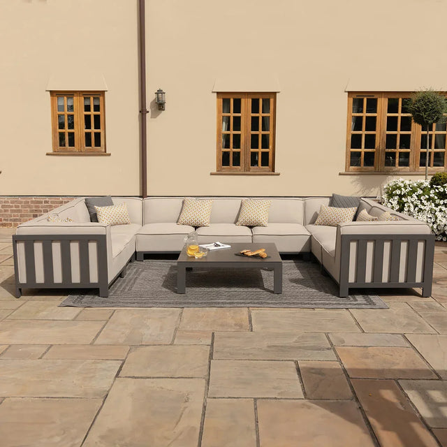 Grey outdoor corner sofa set with cushions and matching coffee table on patio