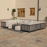 Grey outdoor corner sofa set with cushions and coffee table on stone patio