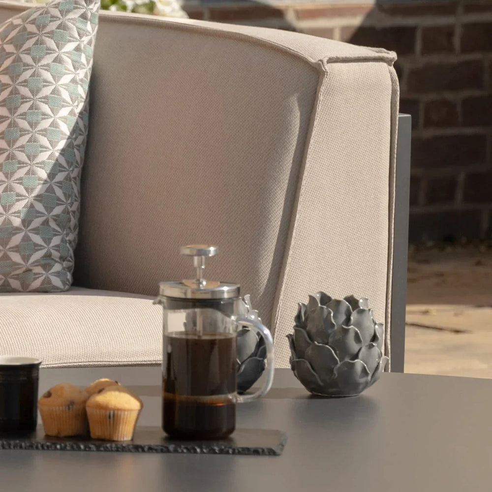 Beige outdoor sofa with geometric cushion and coffee set on garden table