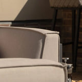 Close view of beige outdoor sofa cushion with textured fabric in sunlight
