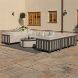 Grey outdoor corner sofa set with cushions and round coffee table on patio