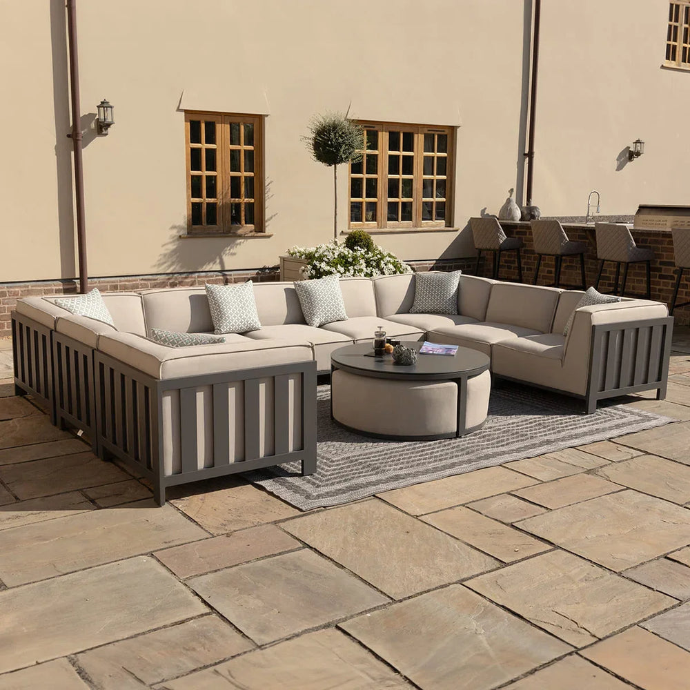 Beige outdoor corner sofa set with grey frame and round coffee table on patio