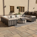 Beige outdoor corner sofa set with grey frame and round coffee table on patio