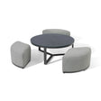 Round coffee table with black top and three curved grey fabric stools grouped around