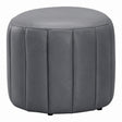 A round gray upholstered ottoman with vertical channel tufting and small black feet, shown on a plain white background.
