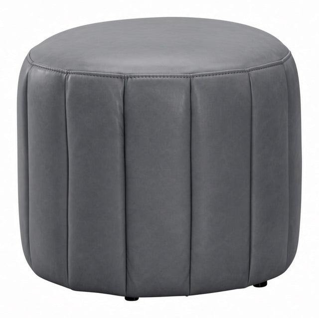 A round gray upholstered ottoman with vertical channel tufting and small black feet, shown on a plain white background.