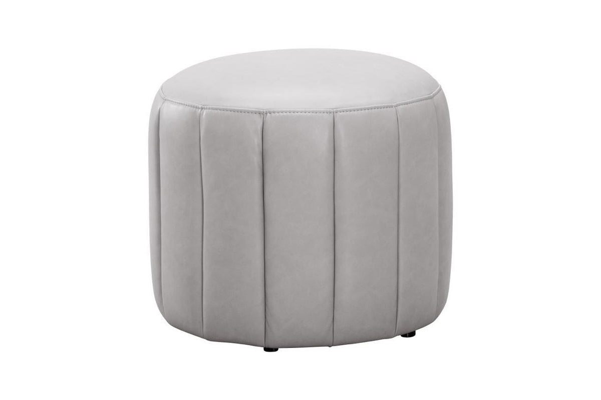 A round, light gray upholstered ottoman with vertical channel tufting, shown against a plain white background.