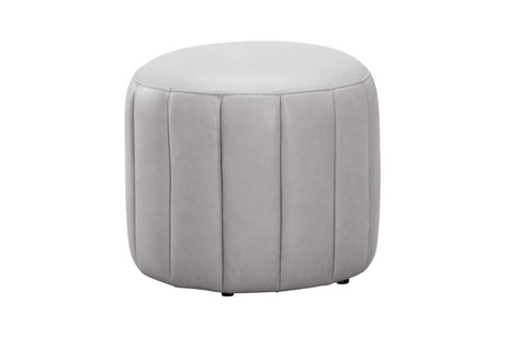 A round, light gray upholstered ottoman with vertical channel tufting, shown against a plain white background.