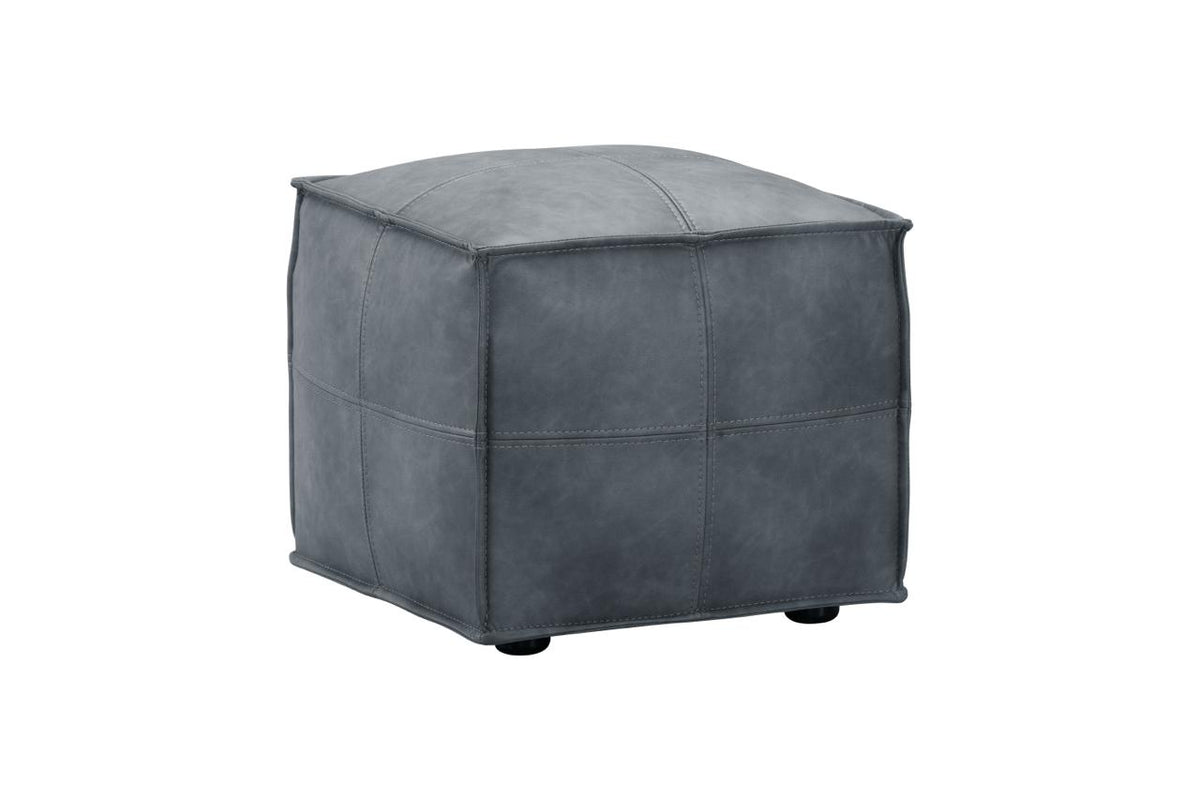 A square gray faux-leather ottoman with stitched panel seams and small black feet, shown on a plain white background.