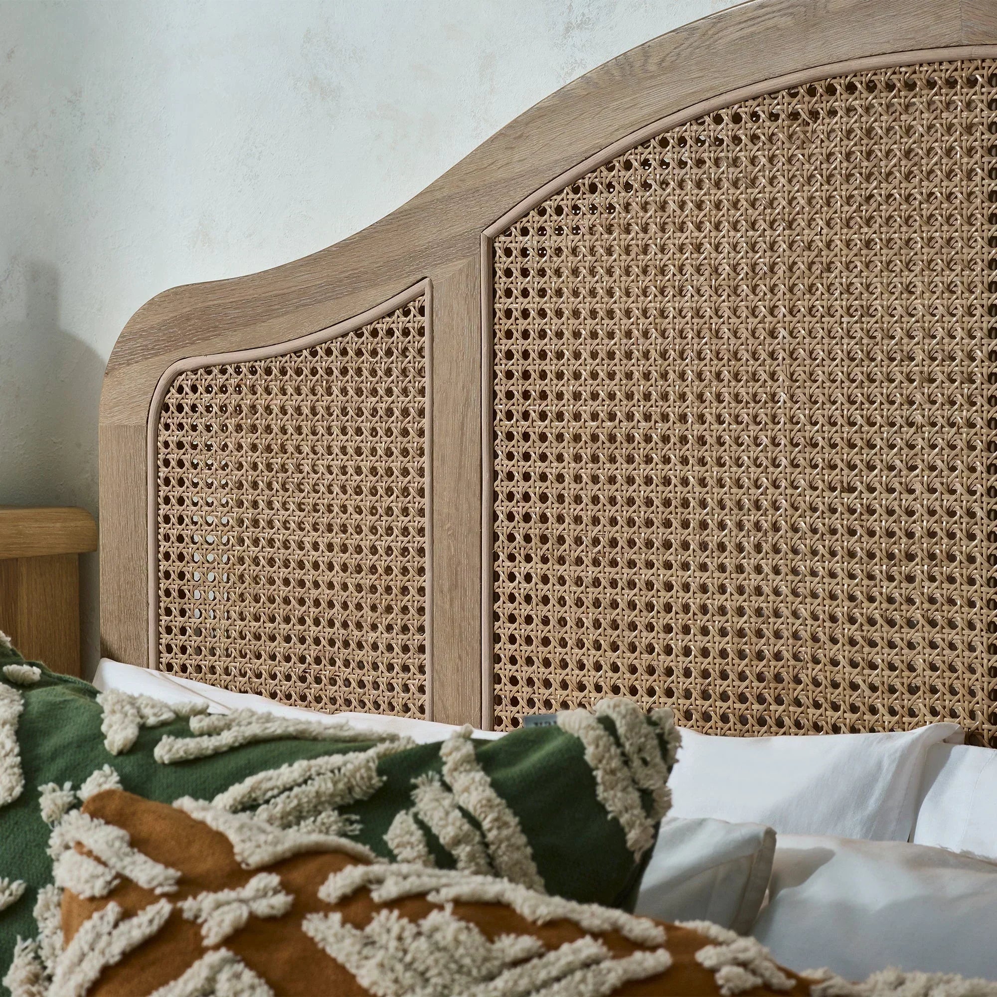 Wooden rattan bed headboard with decorative pillows and textured woven pattern