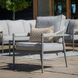 Grey garden lounge chair with cushions and a patterned scatter pillow on patio