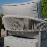 Close-up of grey outdoor lounge chair with rope weave back and padded cushions