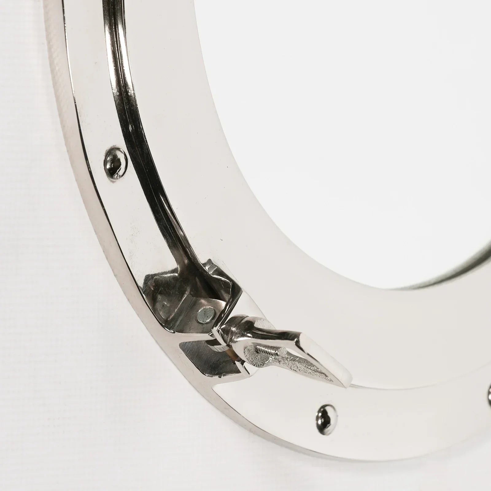 Chrome porthole mirror frame with latch detail and screws