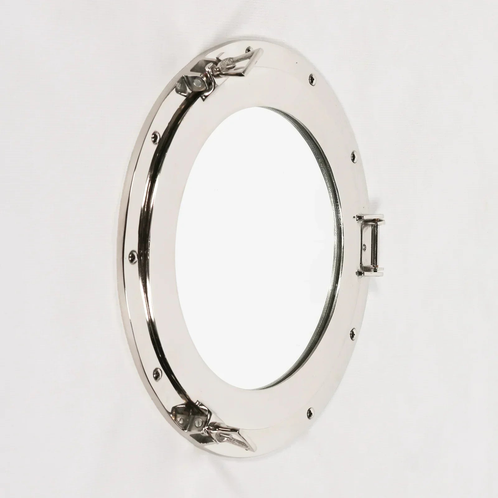 Round porthole wall mirror with polished metal frame and latches, angled side view