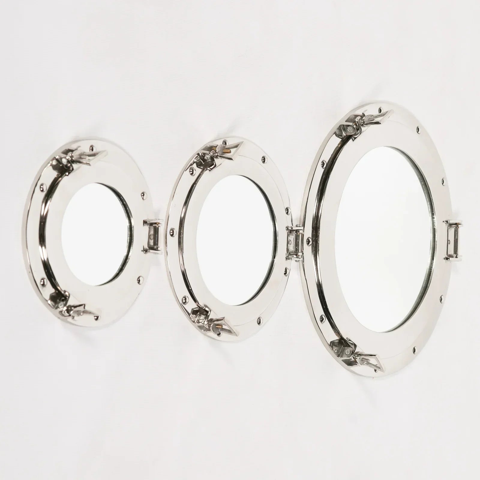 Set of three round porthole wall mirrors with chrome frames on white background