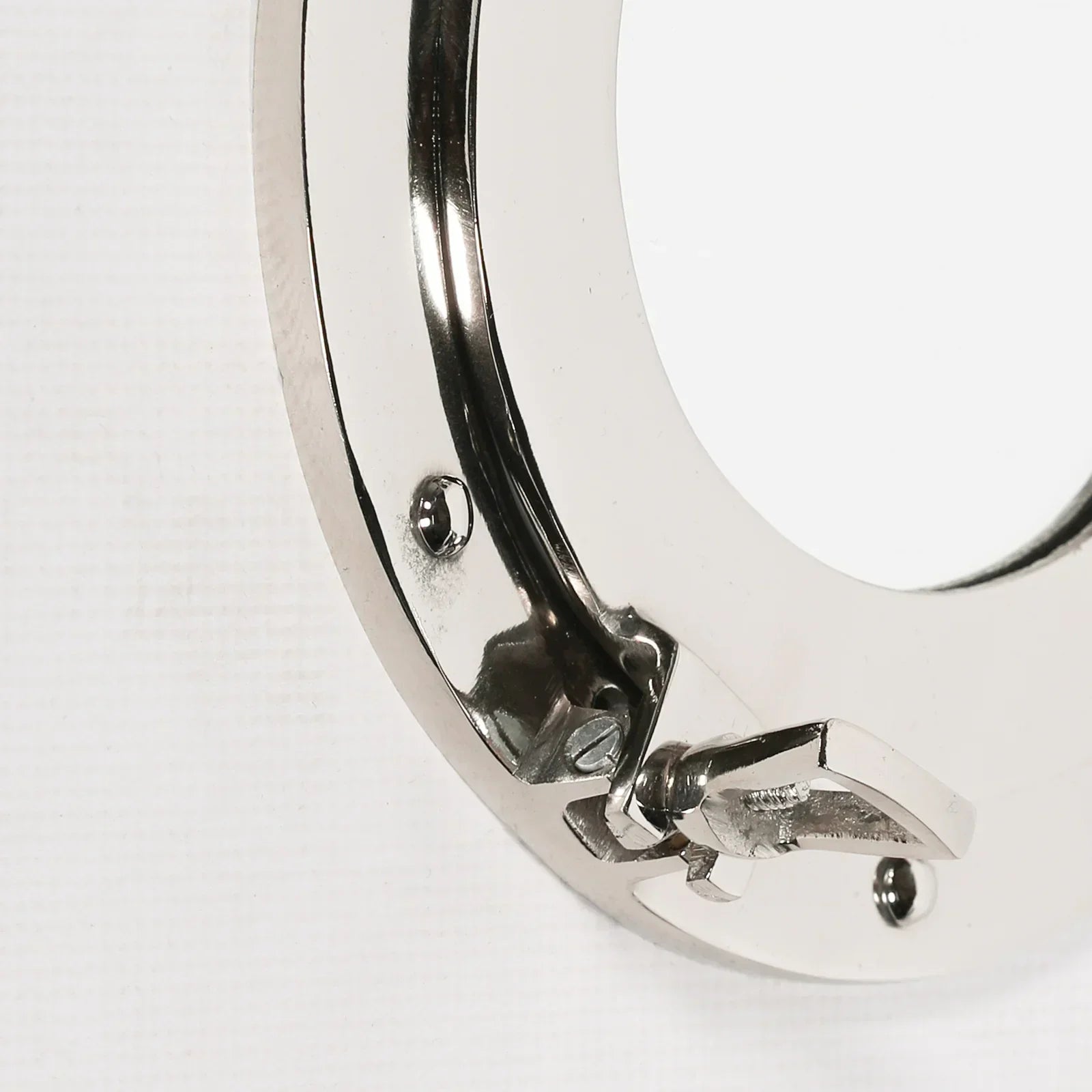 Close up of chrome furniture handle with latch and screw details on white background