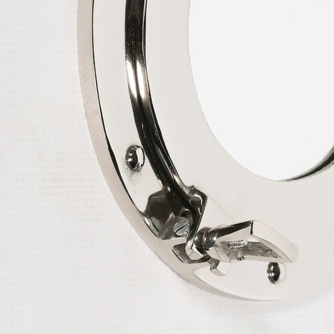 Close up of chrome furniture handle with latch and screw details on white background