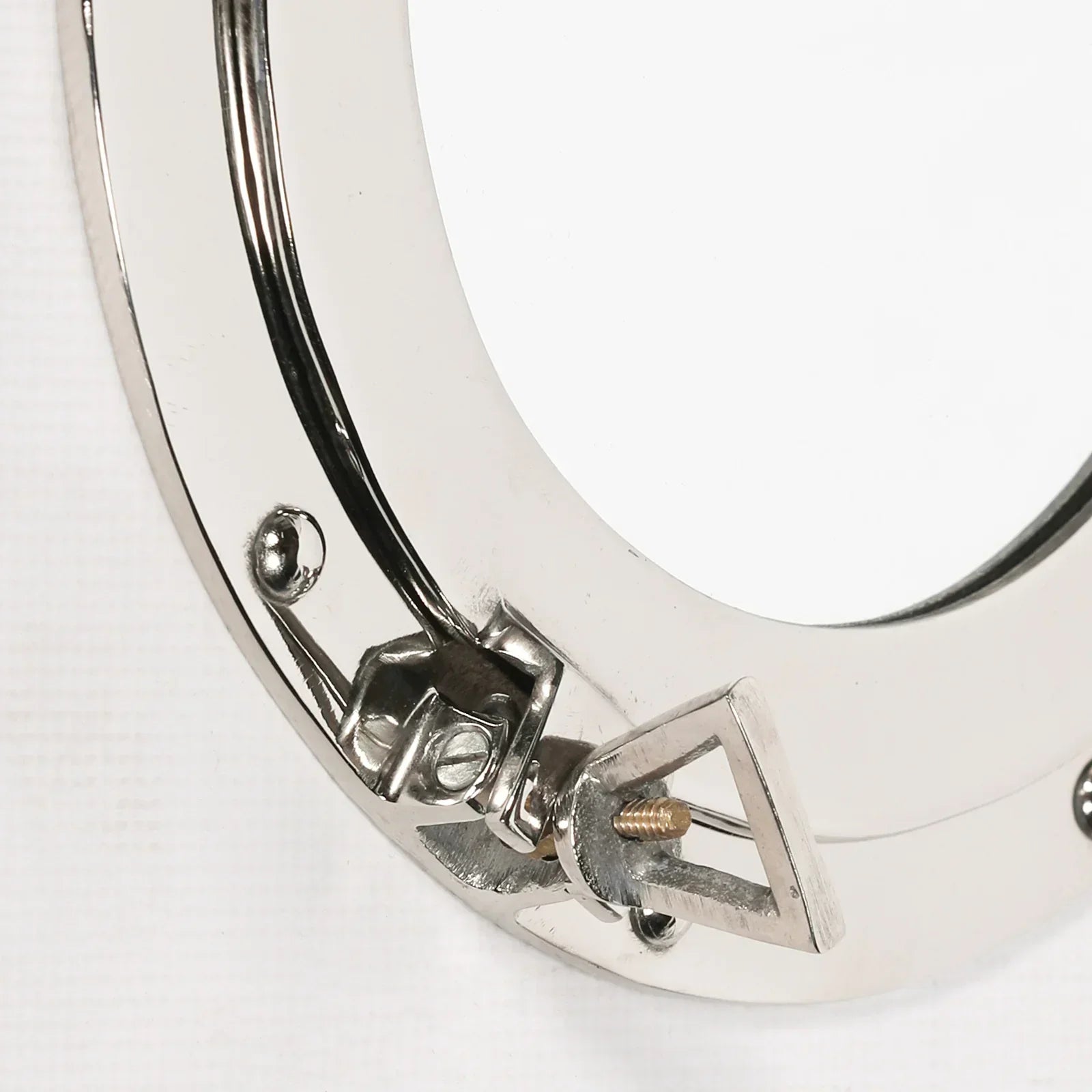 Close-up of chrome porthole mirror frame with metal clasp detail