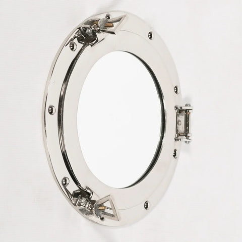 Polished chrome porthole mirror with round frame and hinge detail on white wall