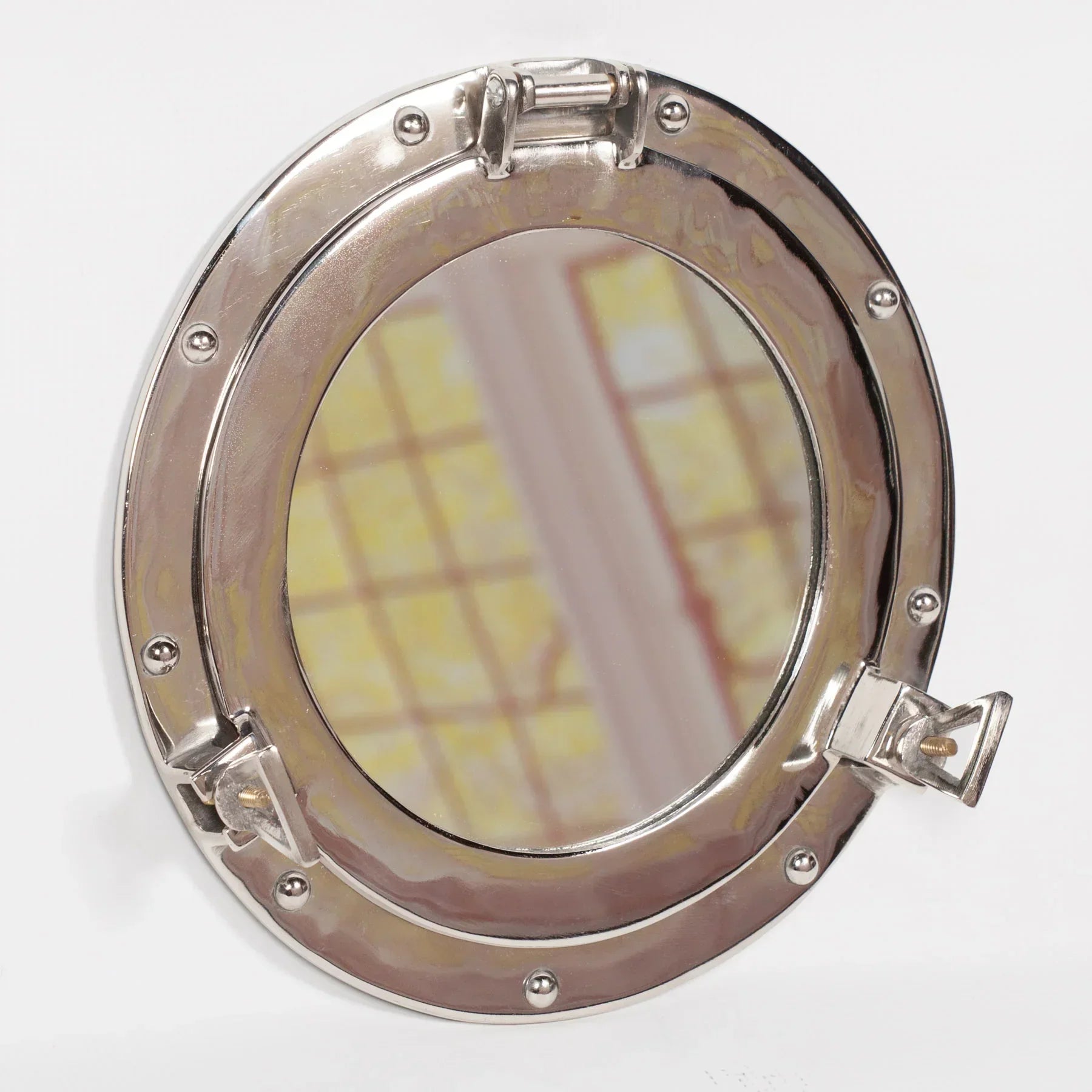 Round chrome porthole wall mirror with rivet details, nautical decor style