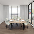 Dining area with a wooden table and chairs in a modern room with large windows.