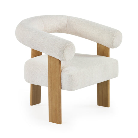Cream boucle upholstered armchair with curved backrest and thick oak legs angled with white background.