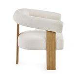 Side view of cream boucle armchair showing curved backrest, thick seat cushion and oak legs on white background.