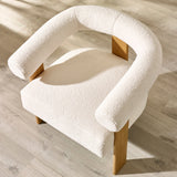 Top angled view of cream boucle accent chair highlighting rounded backrest, thick seat cushion and oak legs.