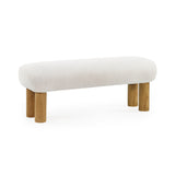 Cream low bench with round wooden legs isolated on white background, angled view.