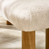Close-up of rounded cream fabric upholstery and light wooden cylindrical leg of low bench.