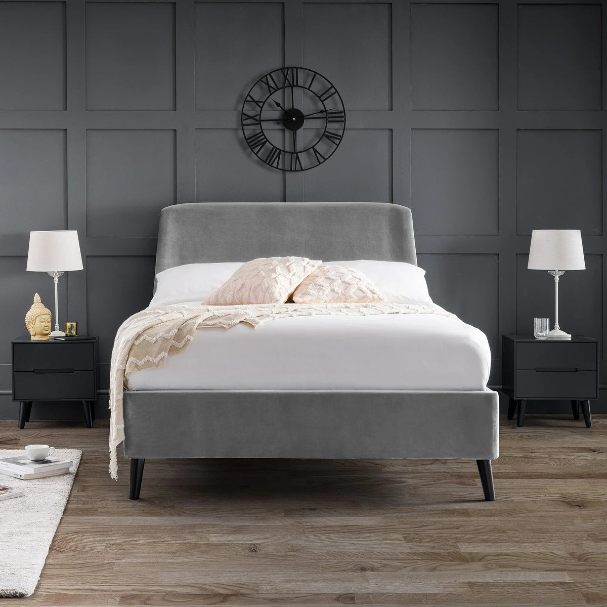 Grey velvet king bed with pillows, set in modern bedroom with black panelled wall and side tables
