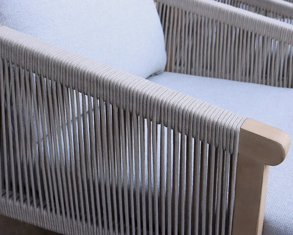 Close view of outdoor rope armchair with light grey cushions and wooden frame