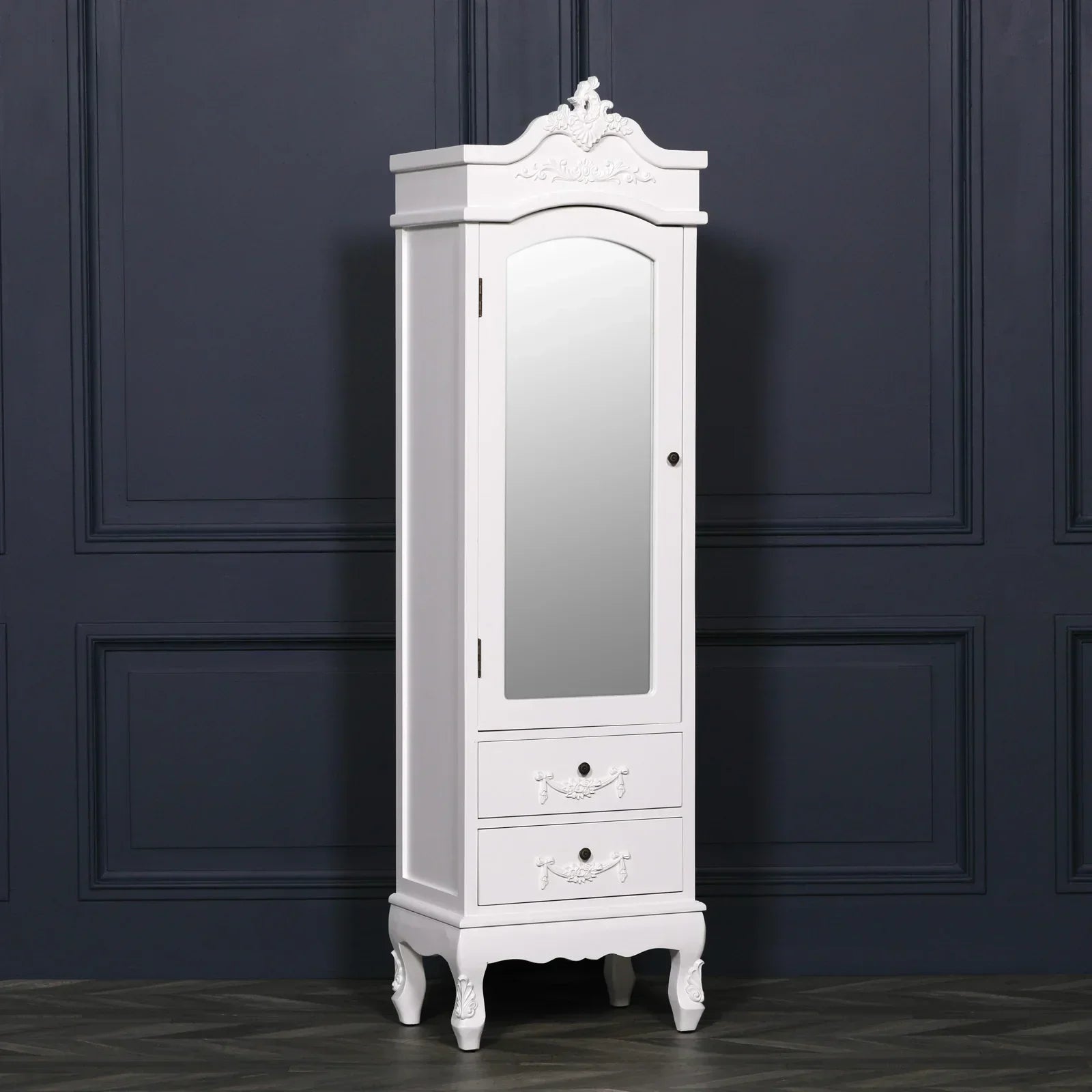 White mirrored wardrobe with ornate detailing and two drawers, set against dark wall