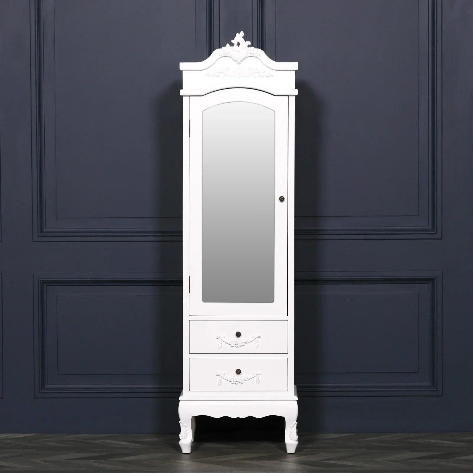 White mirrored wardrobe with two drawers and ornate details against dark wall