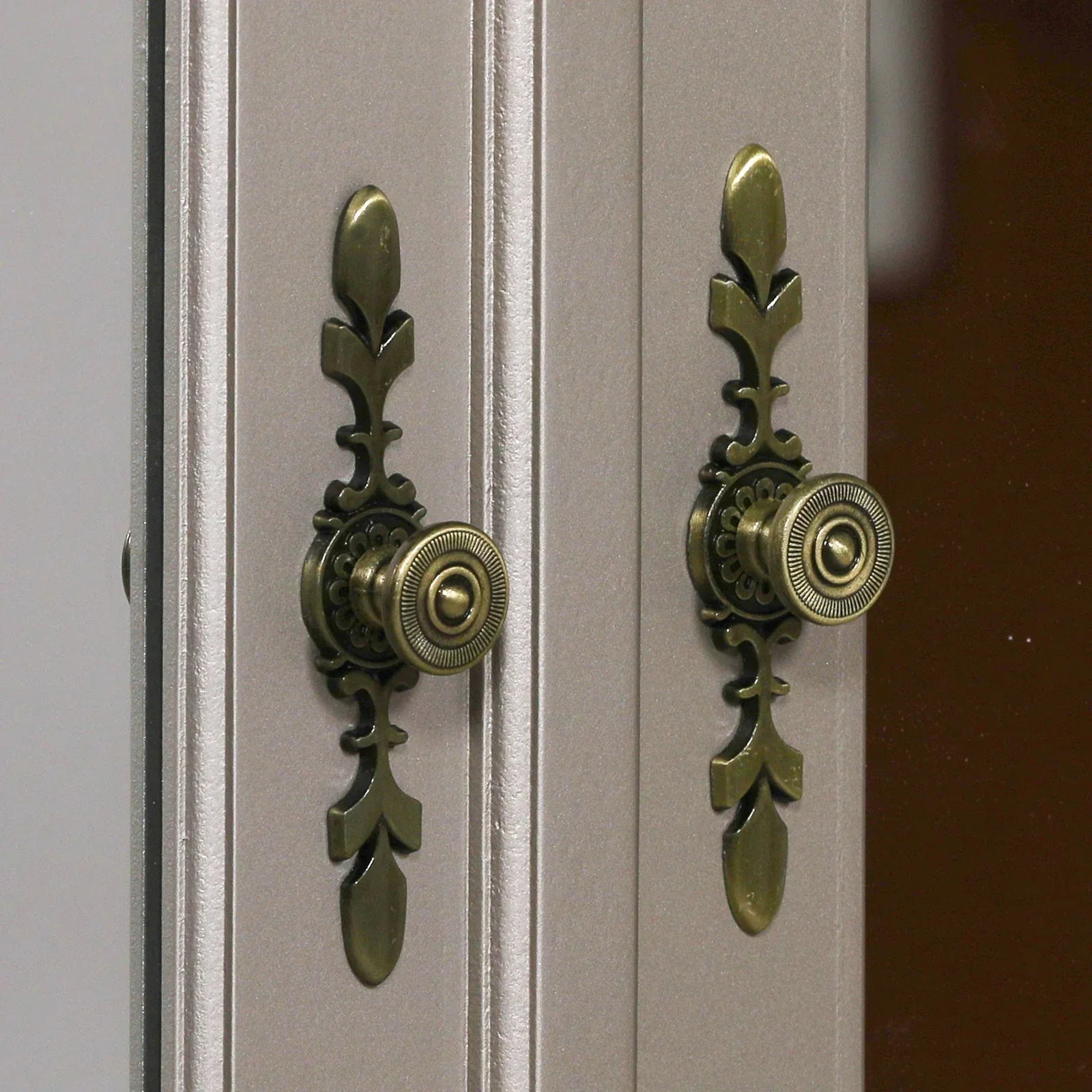 Close up of brass cabinet handles on mirrored wardrobe doors