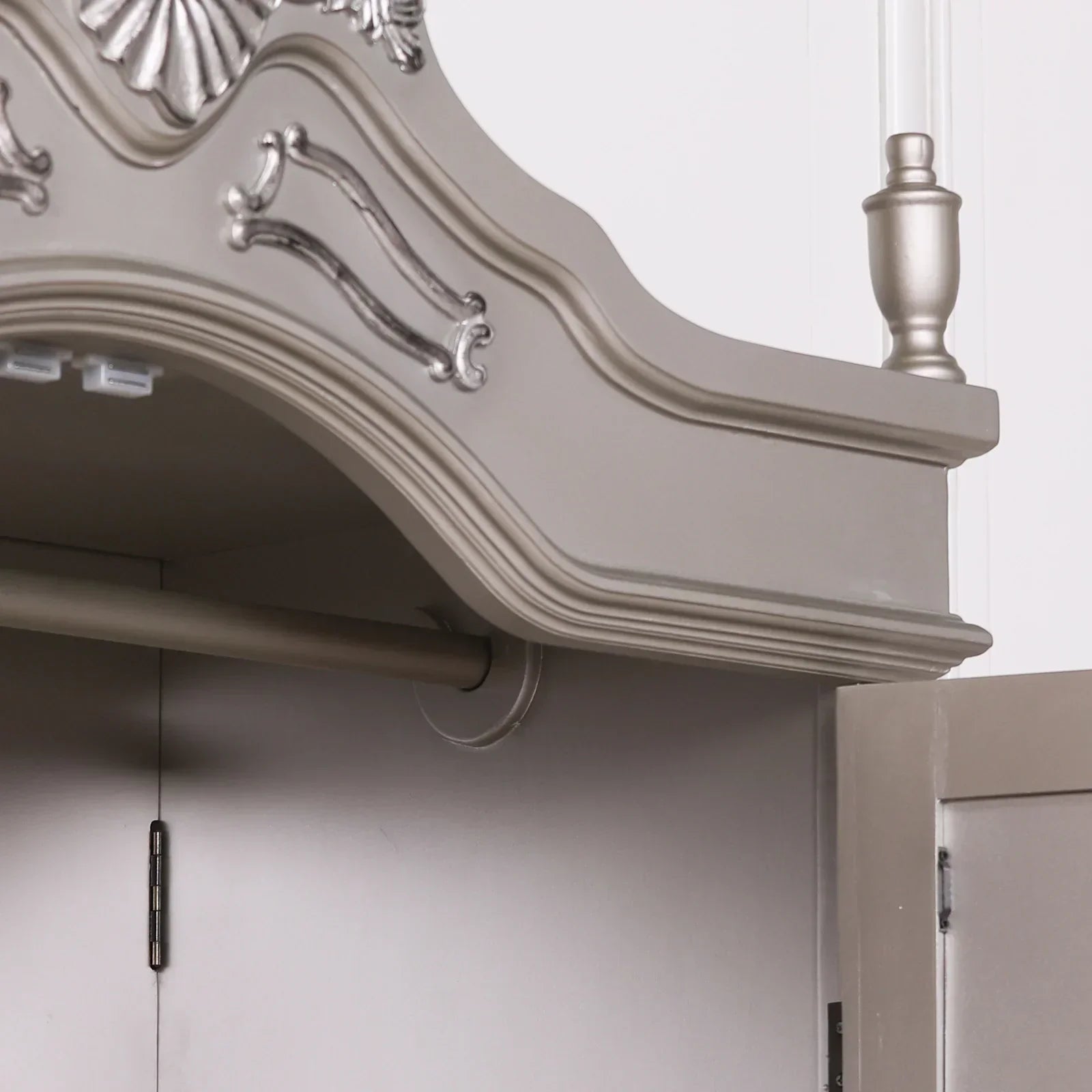 Grey wardrobe top detail with ornate trim and silver accents, open door shown