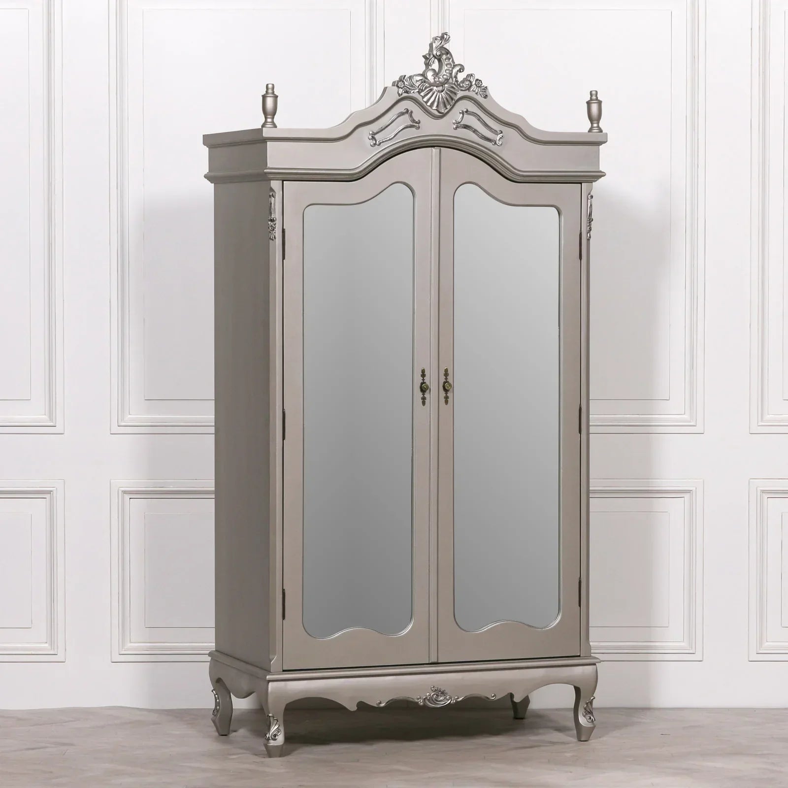 Grey mirrored wardrobe with ornate detailing and double doors against white panelled wall
